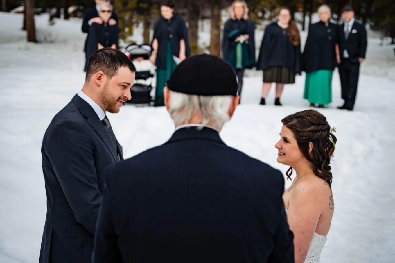 Intimate wedding in Banff. Commissioner gives a speech while bride and groom look at each other. Familly and friends at the background.
