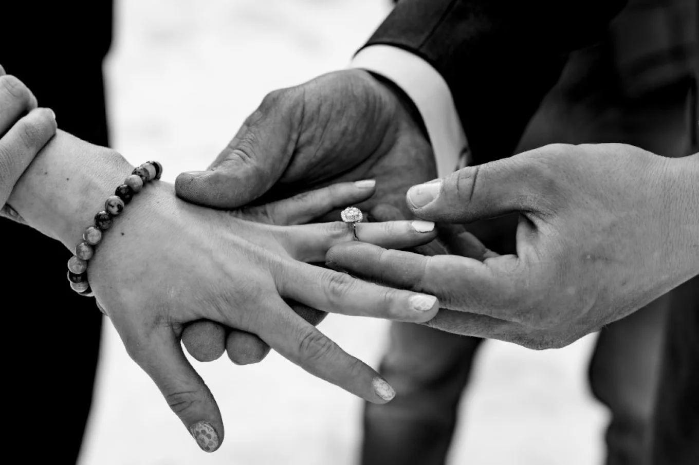 Groom puts wedding ring on the bride's hand.