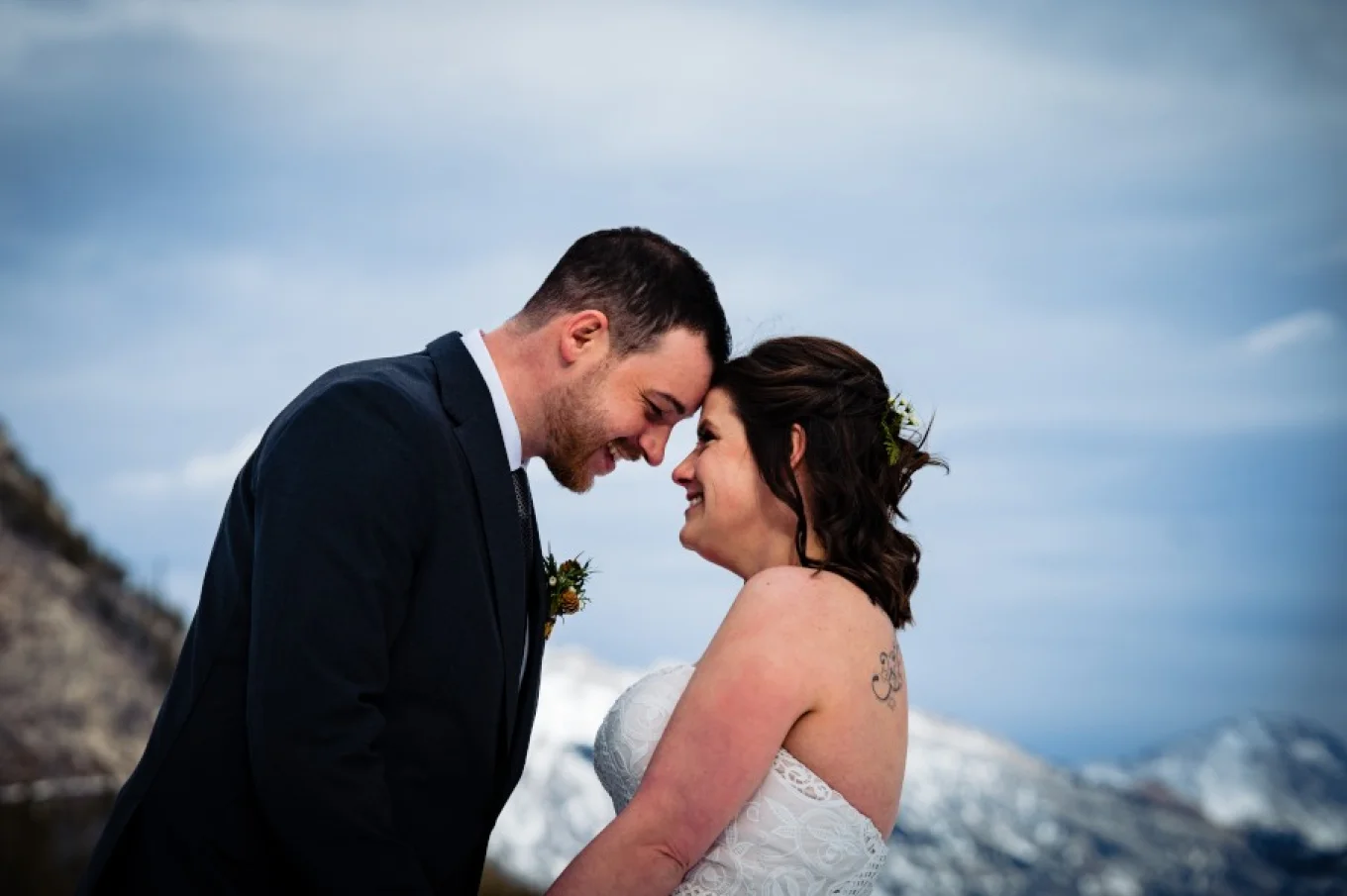 bride and groom touch their forehead and smile.