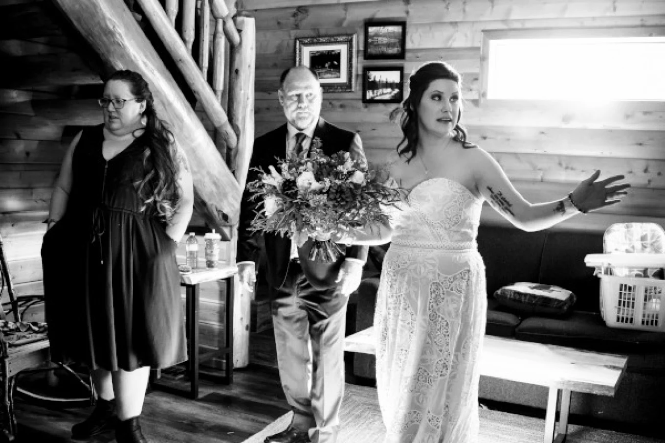 Bride's getting ready time in a cosy cabin in Banff. She points and shows at something behind a window.