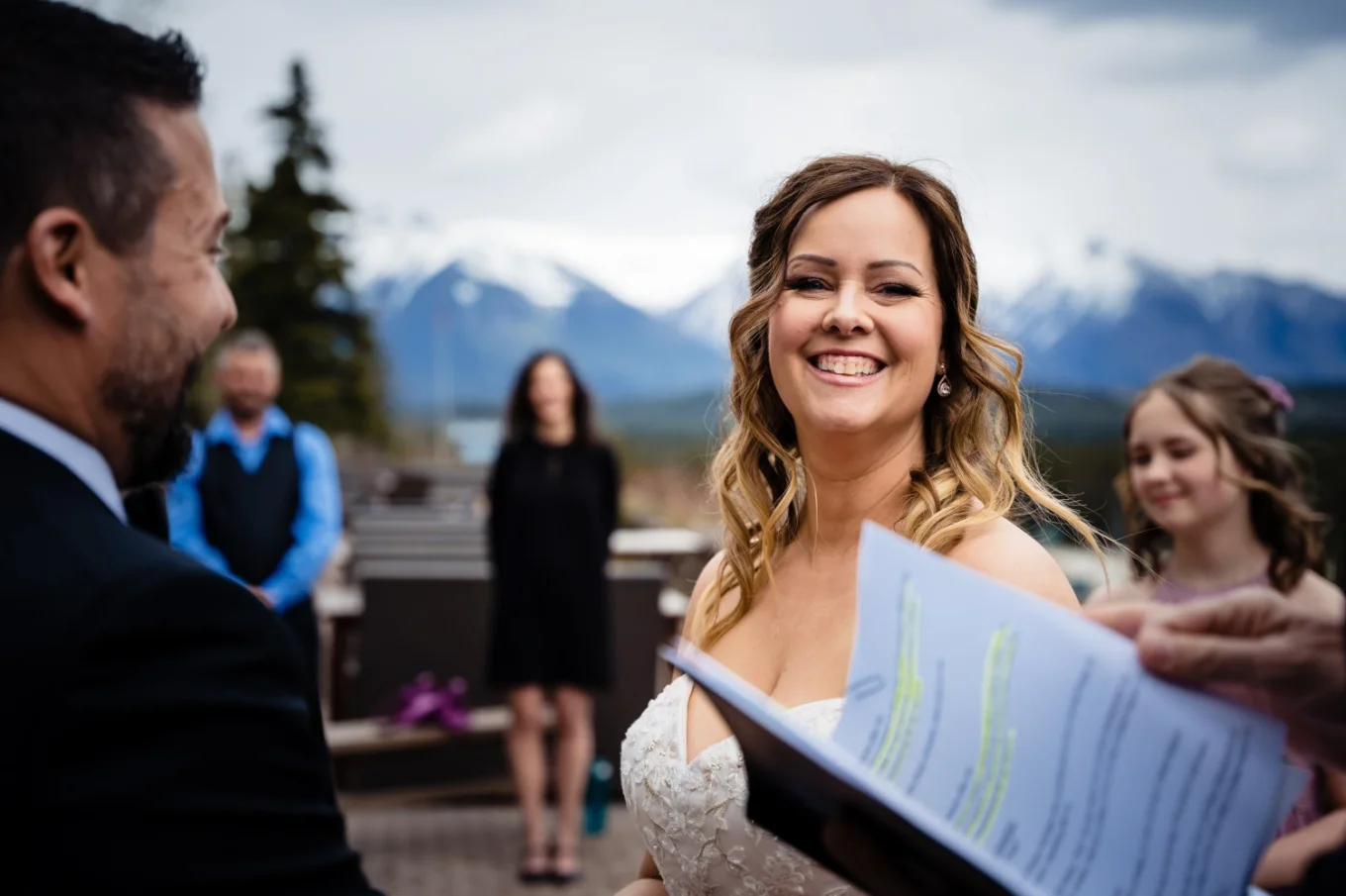 Bride smiles to the officiant during hey wedding ceremony in Banff National Park.