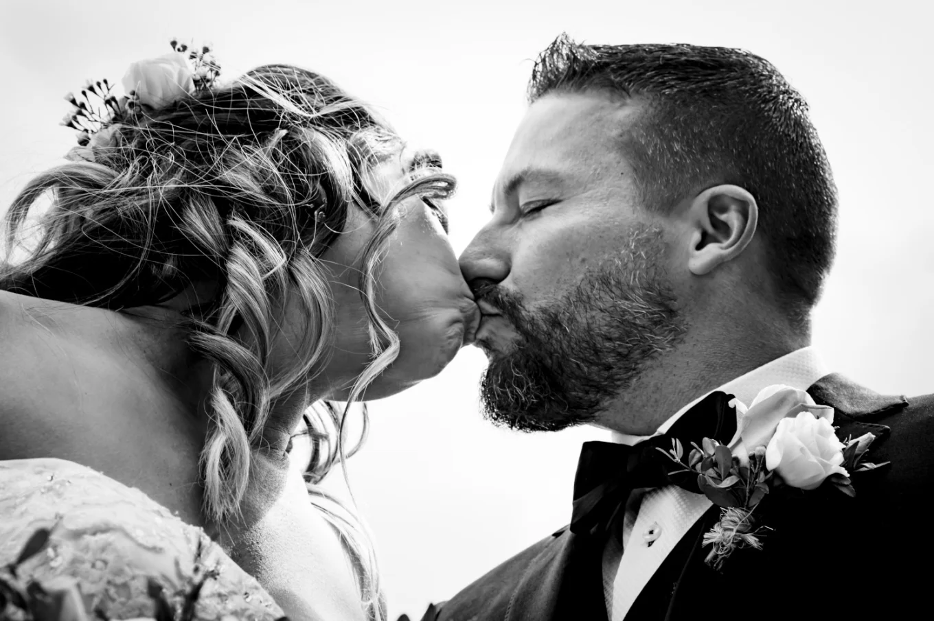Bride;s and groom's first kiss in black and white captured by Calgary Wedding Photographers.