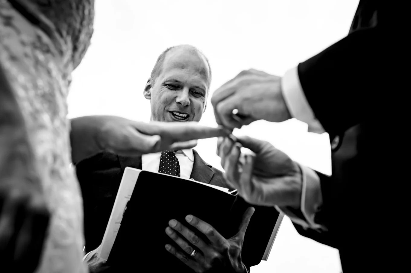 Groom puts a wedding ring on the bride's finger.