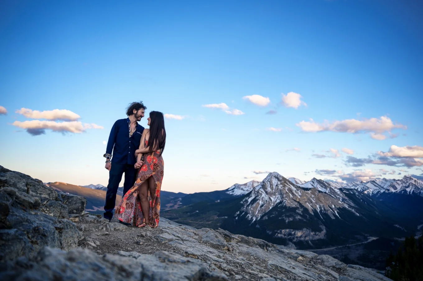 Artistic portrait of engaged couple against a background of sky.
