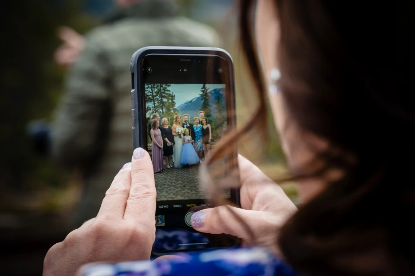 Lady takes a picture of their family after wedding ceremony in the Canadian Rockies.