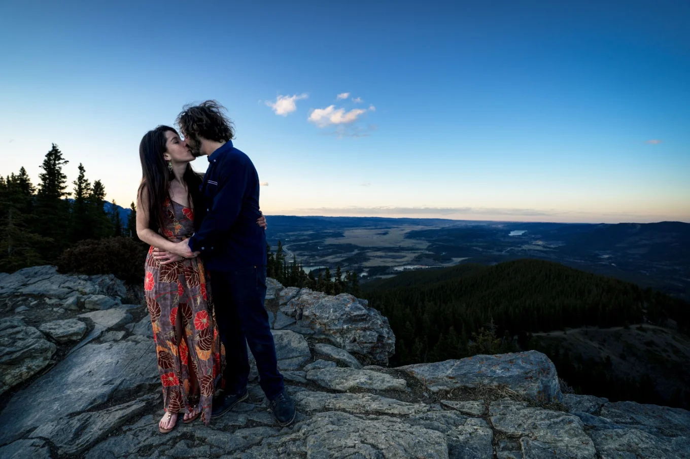 Engaged couple share a kiss during mountain session captured by Calgary Wedding Photographer