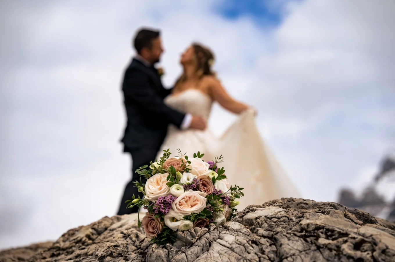 bouquet of flowers. On the background kissing newlyweds