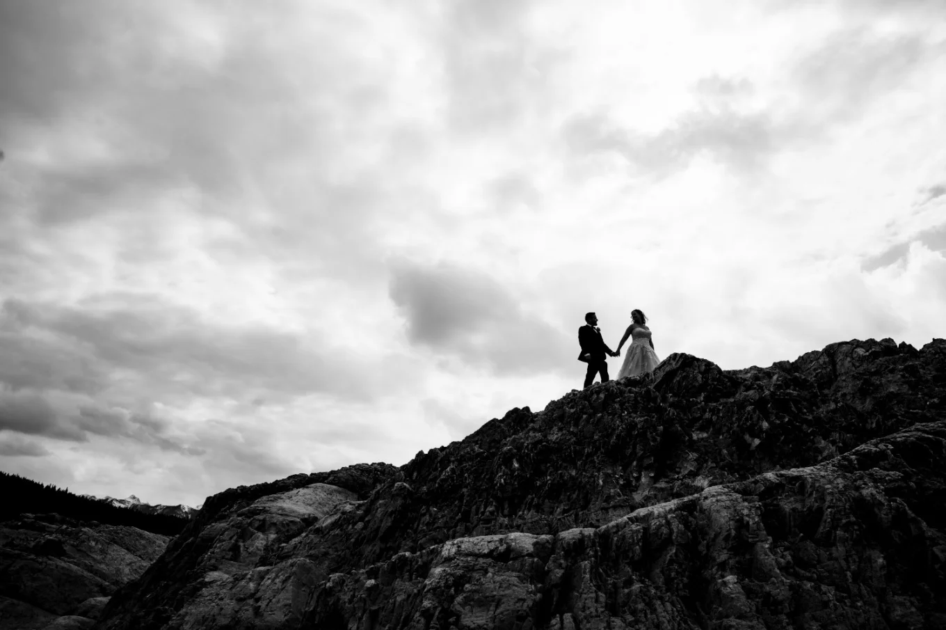 Black and white photograph of newlyweds walking on the top on the mountains in the Canadian Rockies,