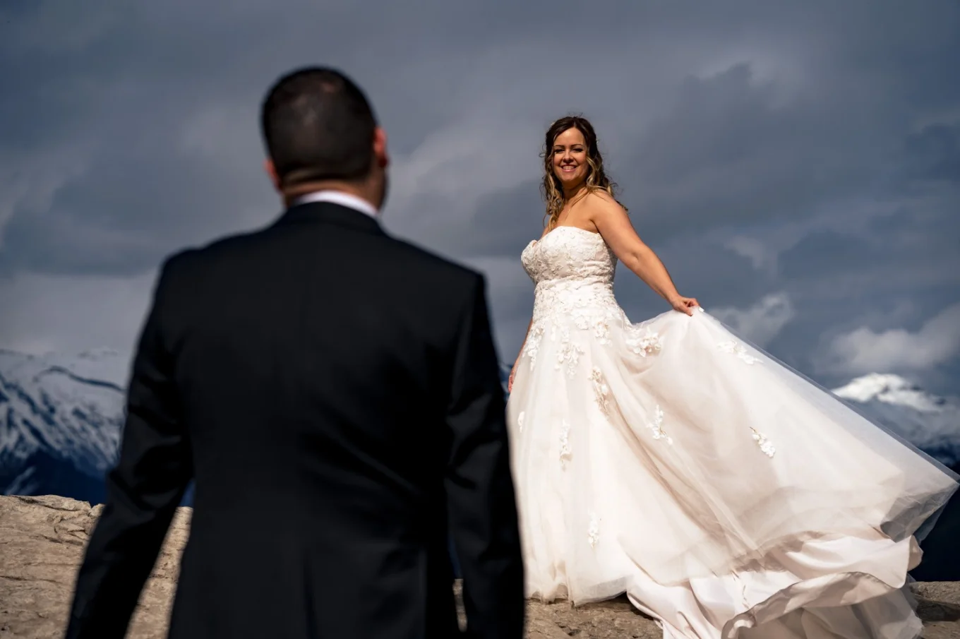 Bride holds her wedding dress and look at the groom.