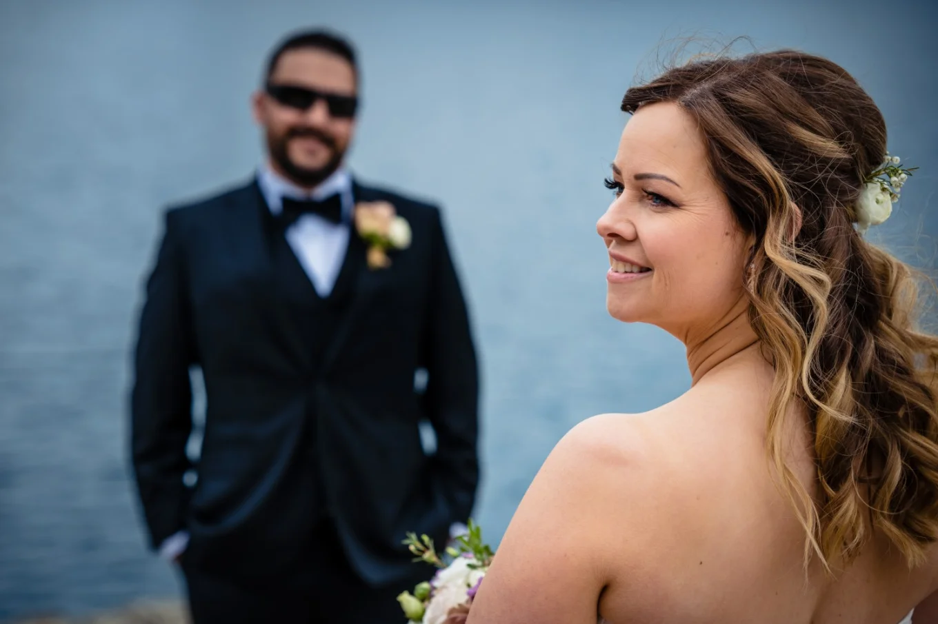 Groom adores the beauty of his wife. The bride looks on the right.