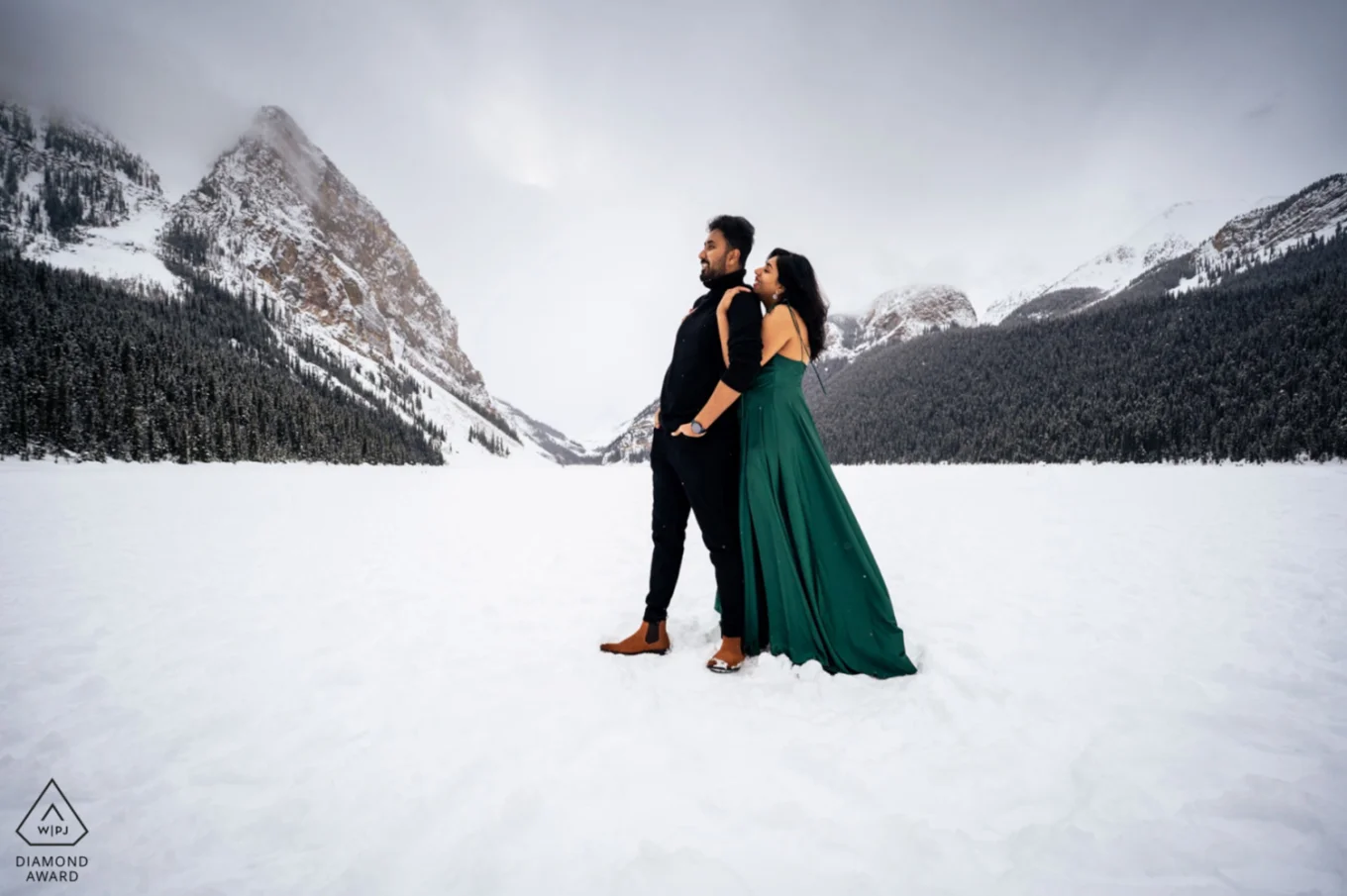 Couple in love in a hug at the frozen Lake Louise in Banff.