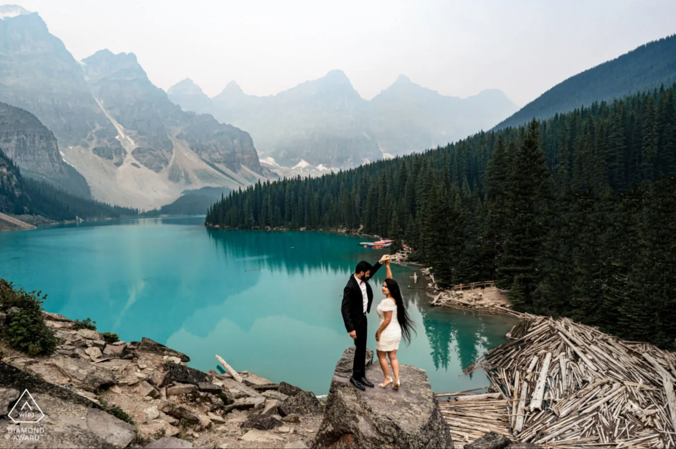 A couple dancing on the giant rock at Moraine Lake in Canada.