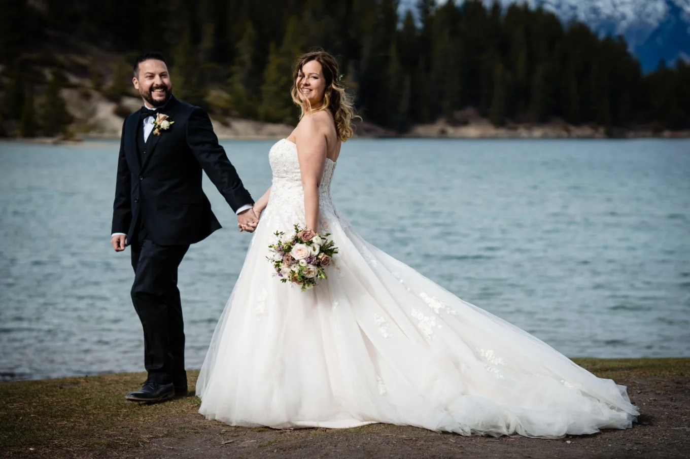 Bride and groom by the Minnewanka Lake in Banff.