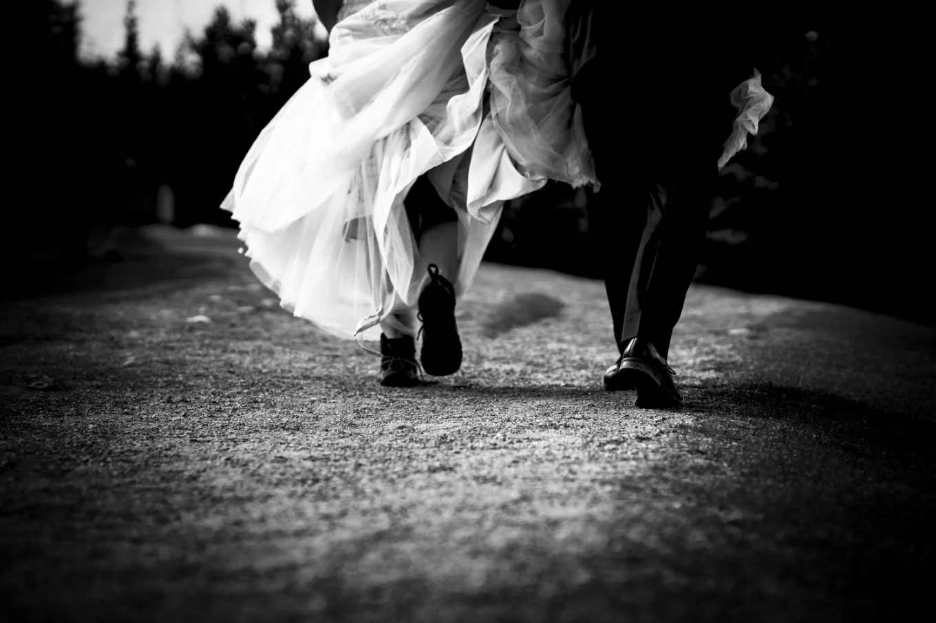 bride's and groom walk. she wears hiking boots.