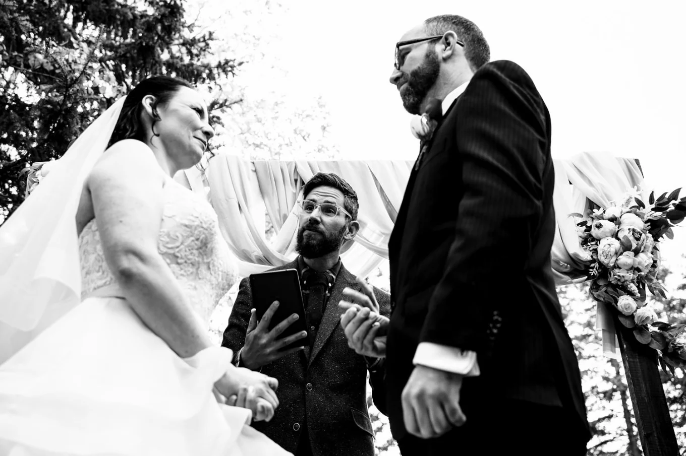 Officiant gives a speech to bride and groom during Banff Wedding. Black and White Photograph taken by the best Banff Wedding Photographer.