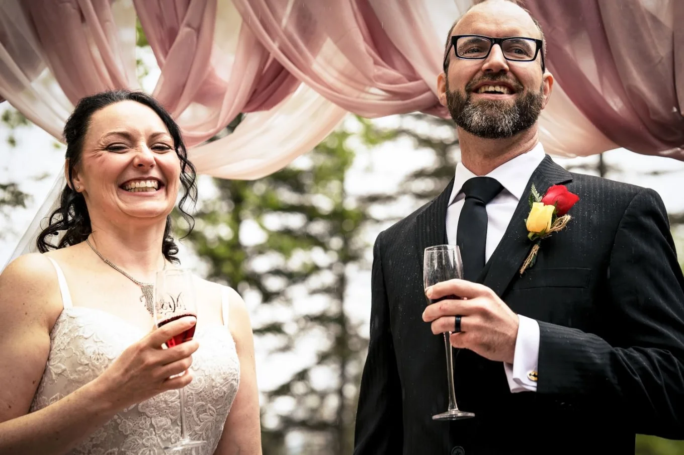Newlyweds drink champagne and smile after wedding ceremony