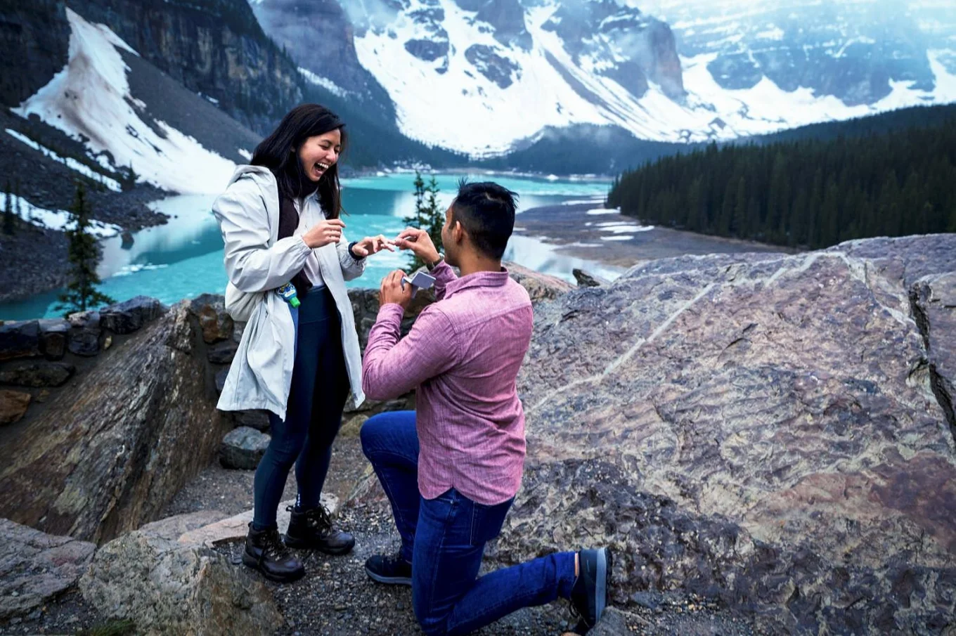 Engagement in Banff. Man puts an engagement ring on his fiancee finger.