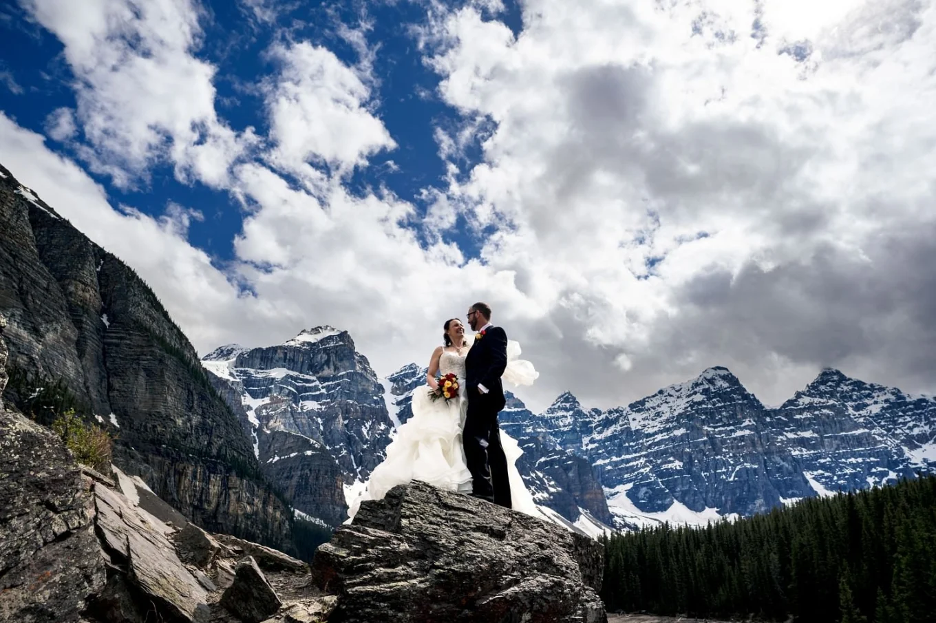 Stunning wedding portrait in the mountains captured by Banff Wedding Photographers. Newlyweds look at each other ans smile.