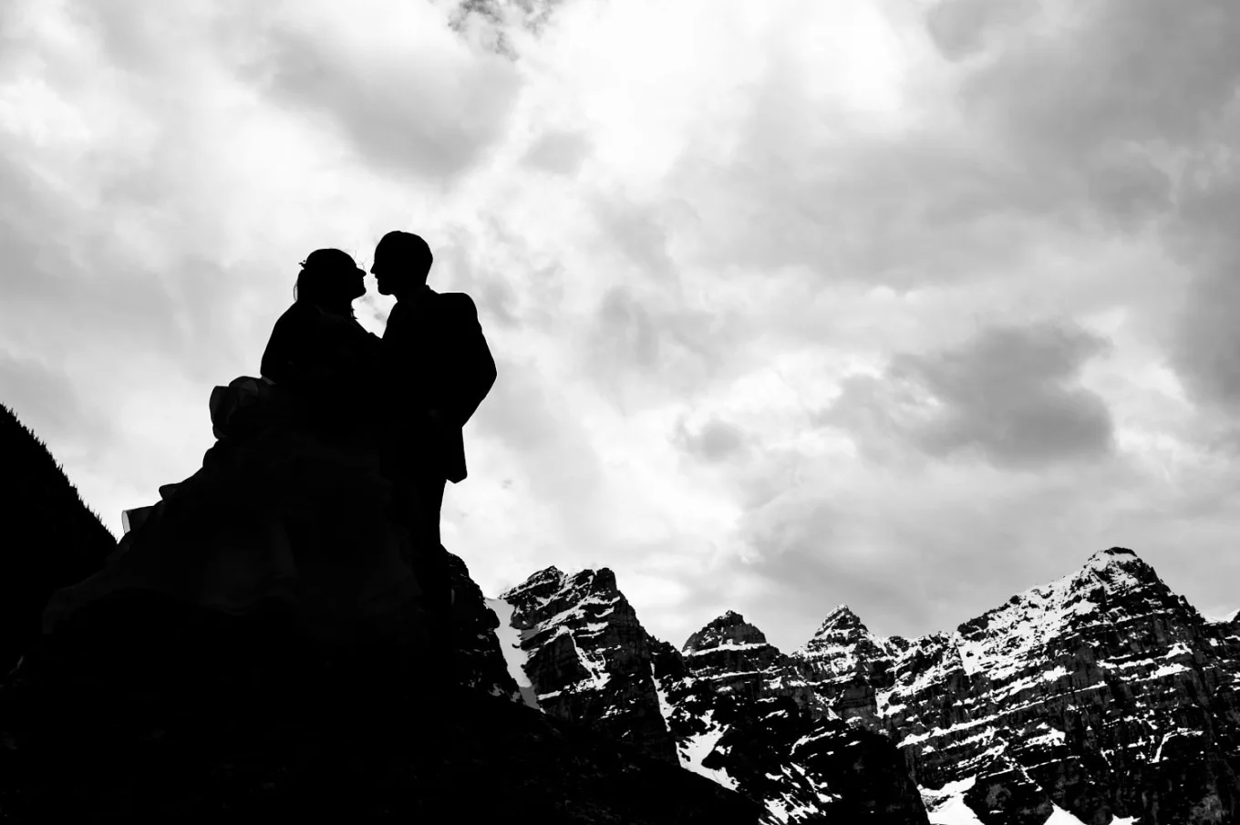 Newlyweds silhouette in the mountains in black and white taken by the best Calgary Wedding Photographer