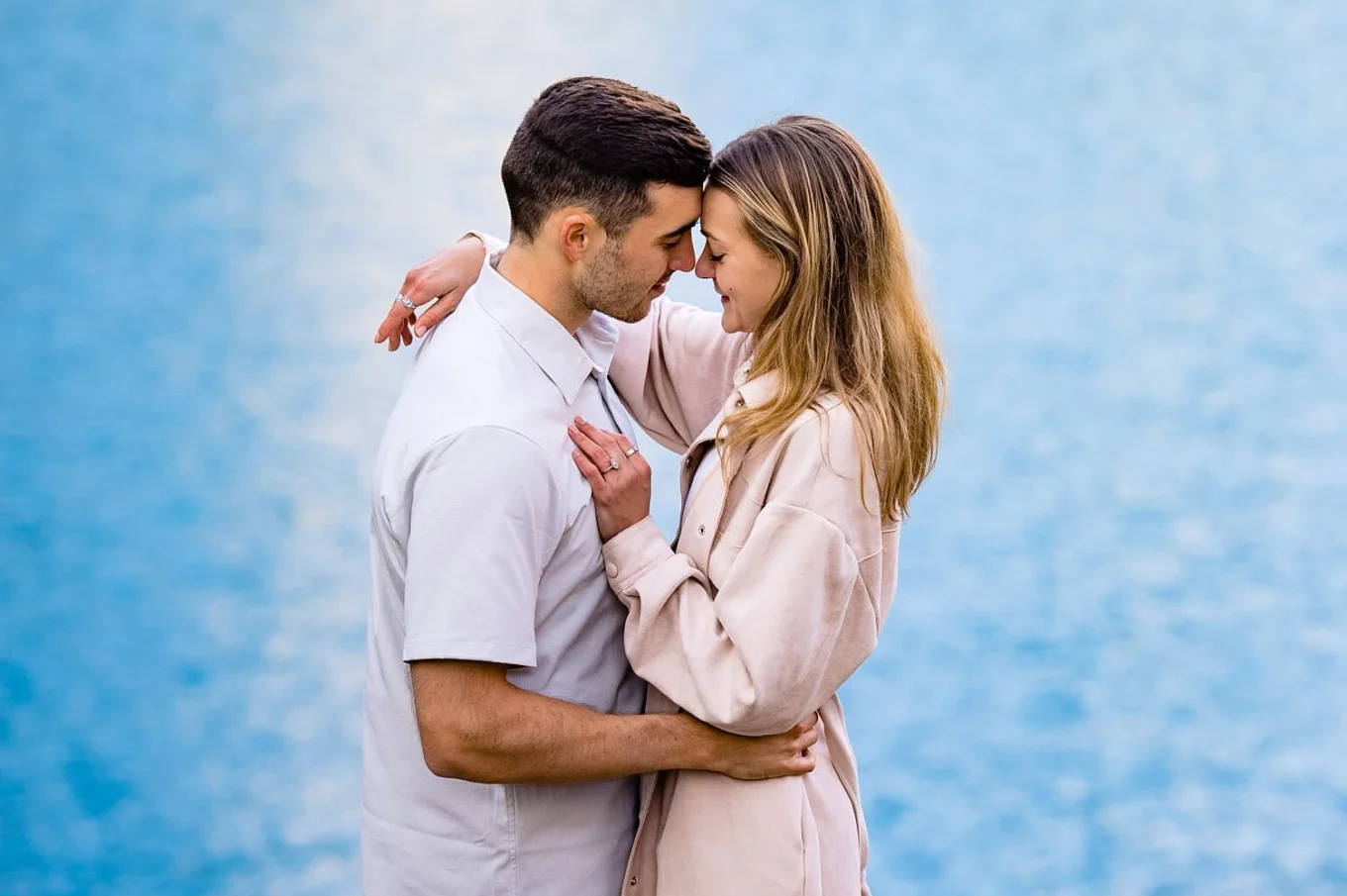 Couple in love touches their heads and hug during their engagement session inn Banff