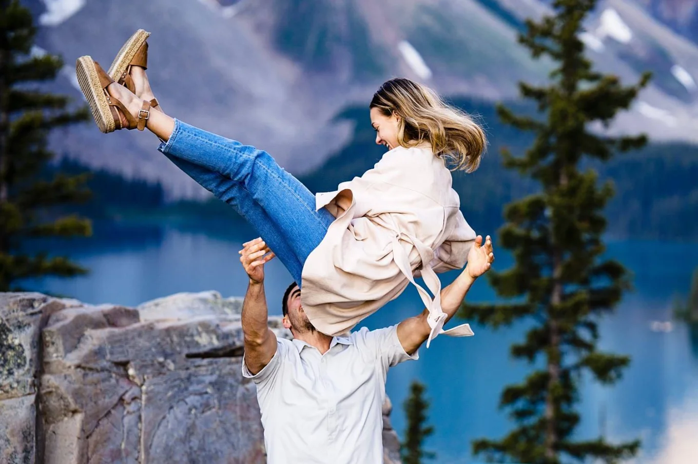 Man tossing his fiancee during engagement session in Banff.