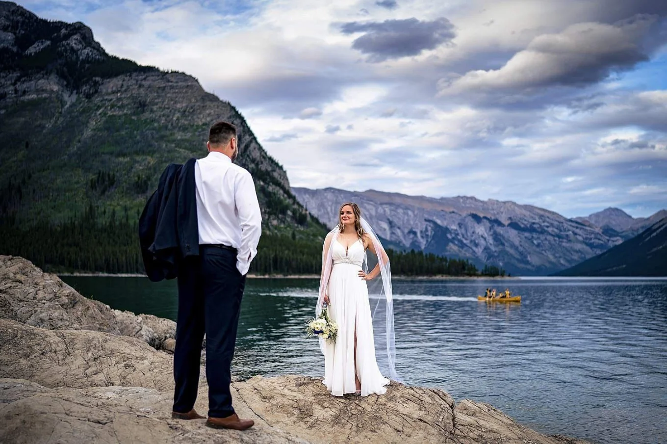 Bride and groom look at each other surrounded by the mountains in Banff
