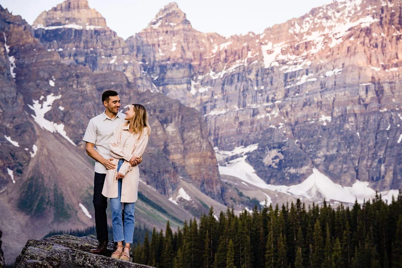 Post proposal portrait of hugging couple with the Canadian Rockies skyline.