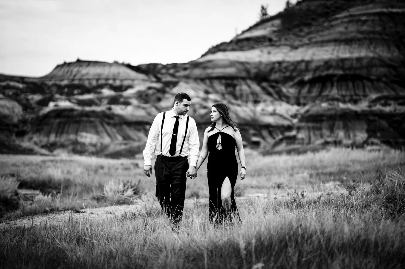 Married couple walk at the Horseshoe Canyon holding their hands and look at each other.