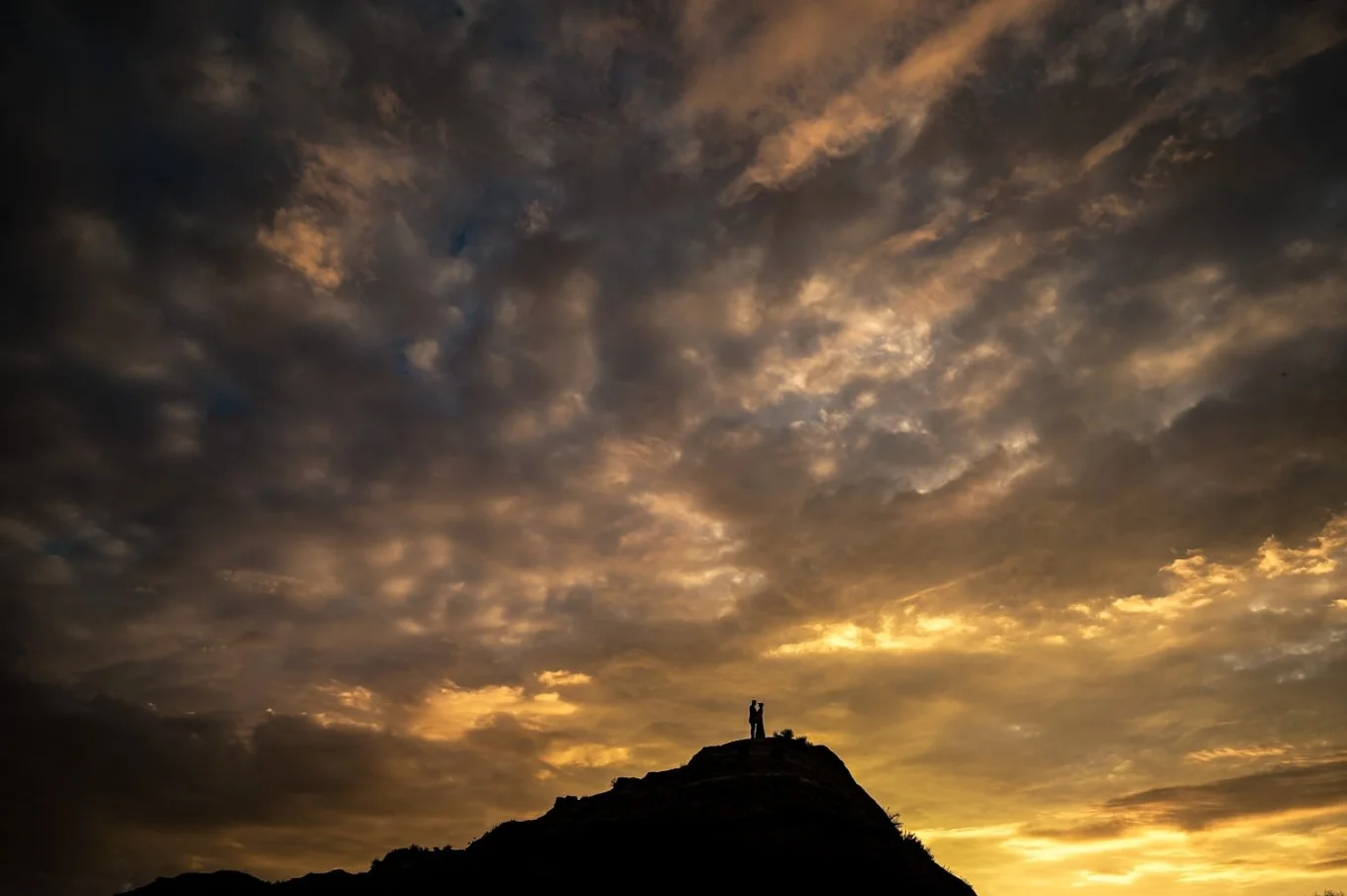 Tiny people in the frame standing in a giant Horseshoe Canyon during spectacular sunrise.