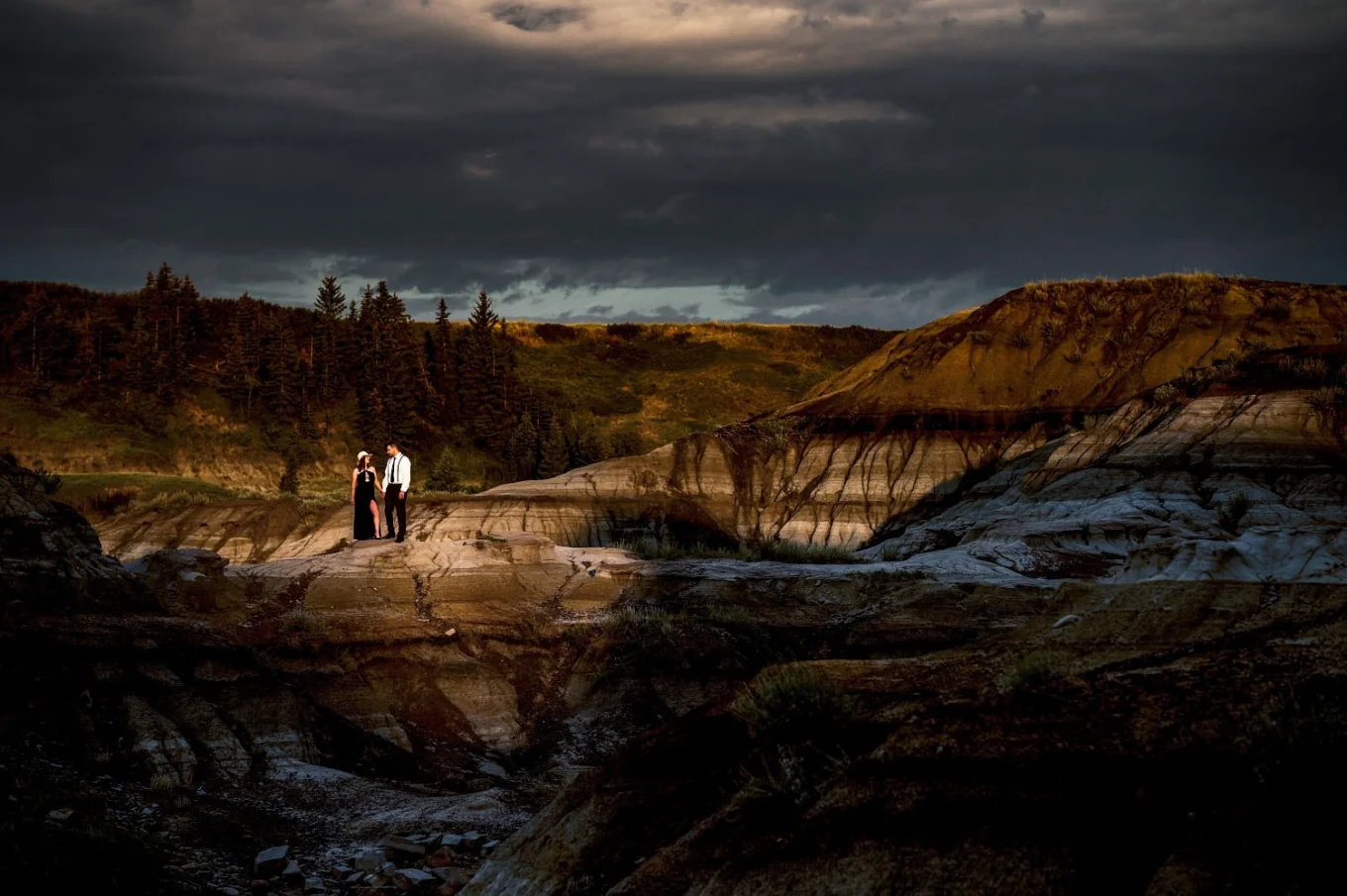 Stunning Photograph of couple holding hands highlighted by sun in Horseshoe Canyon in Alberta. Photo taken by Calgary Wedding Photographer Eliza Slobodzian.