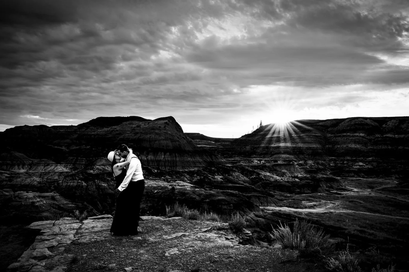 Amazing photograph of hugging couple against Horseshoe Canyon in Drumheller Alberta.