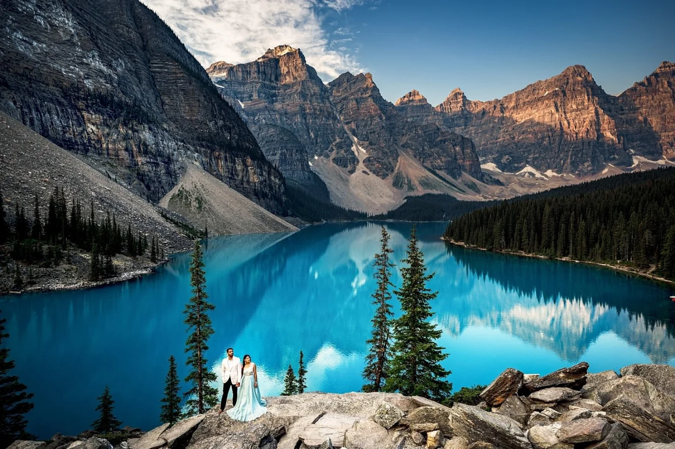 Amazing turquoise Moraine Lake and tiny engaged people surrounded by the Canadian Rockies.