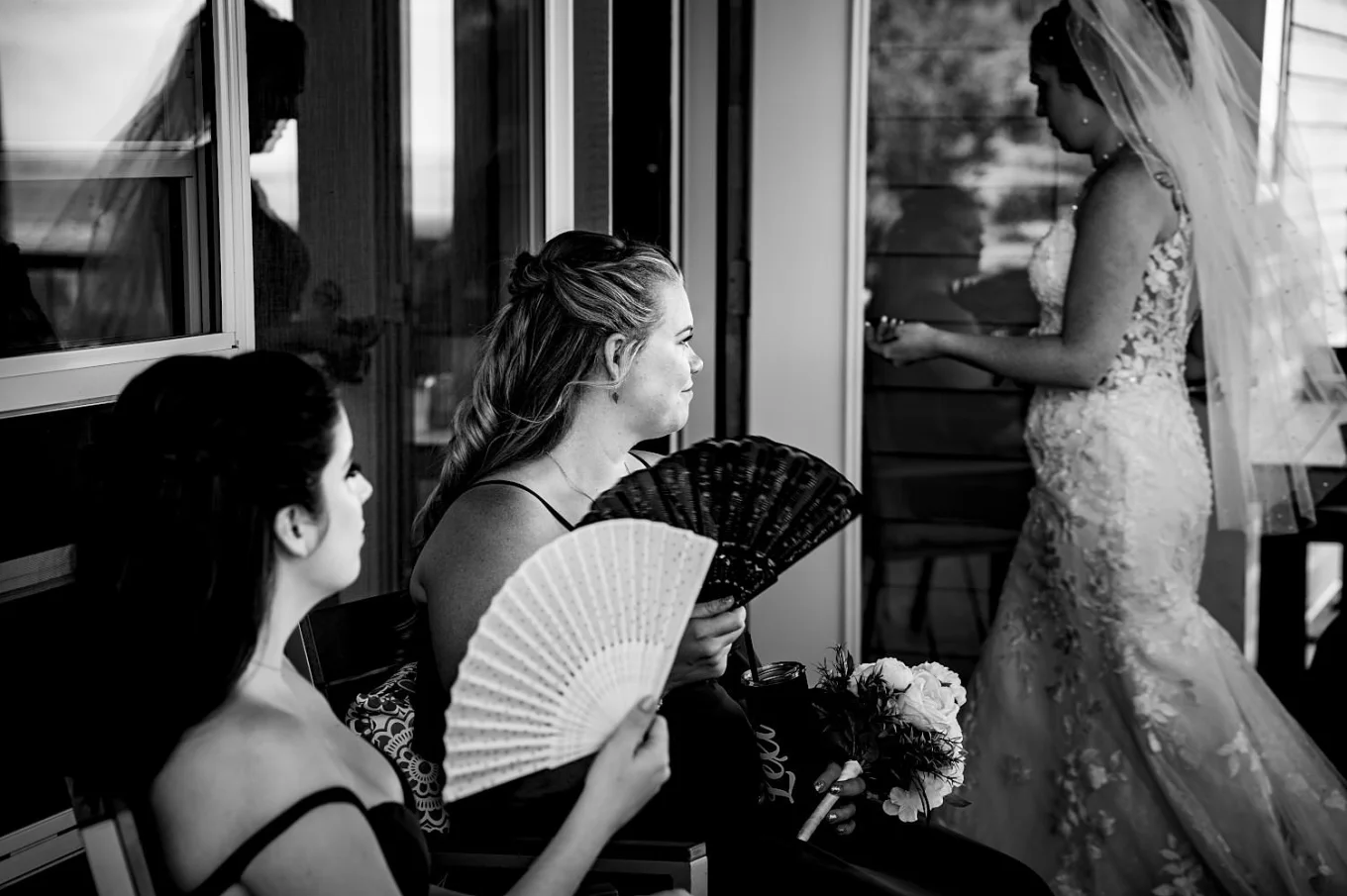 Bridesmaids cooling themselves down with the hand fans on the hot, summer Calgary Wedding.