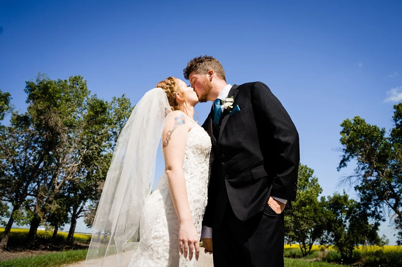 Bride and groom share a kiss during sunny wedding in Calgary