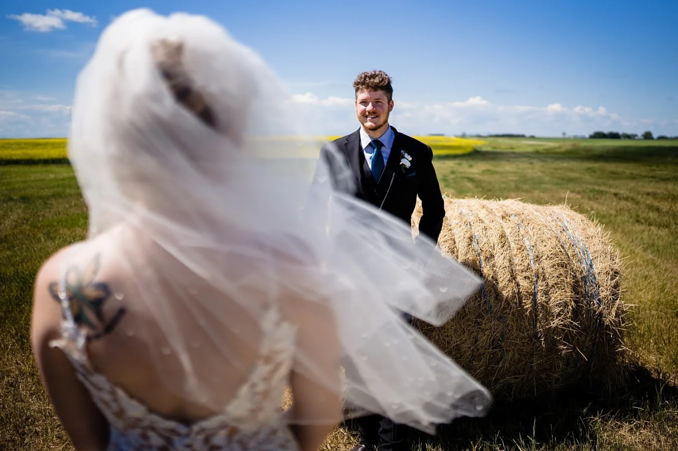 groom lean over on hay cone and look at the bride