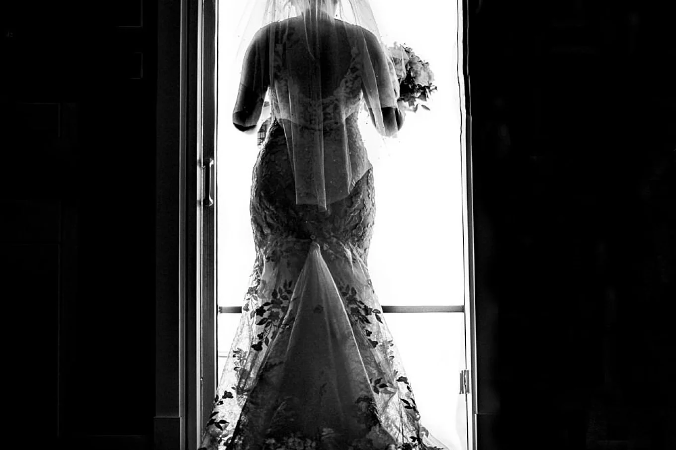 Bride's photograph from the back leaving the house.