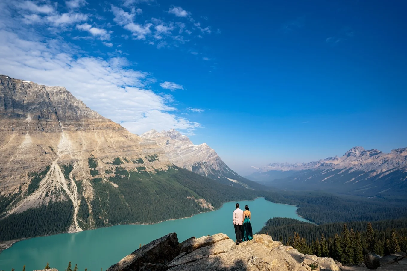 Couple in love adore stunning view if blue Peyto Lake and the Canadian Rockies.