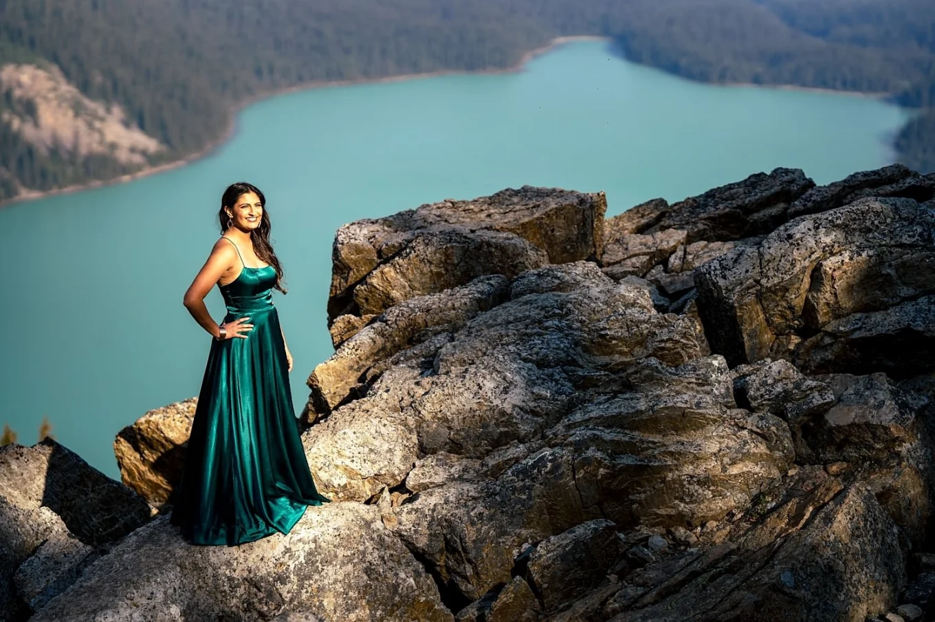 beautiful Indian lady in a long, green dress stands by the peyto Lake in Canada.
