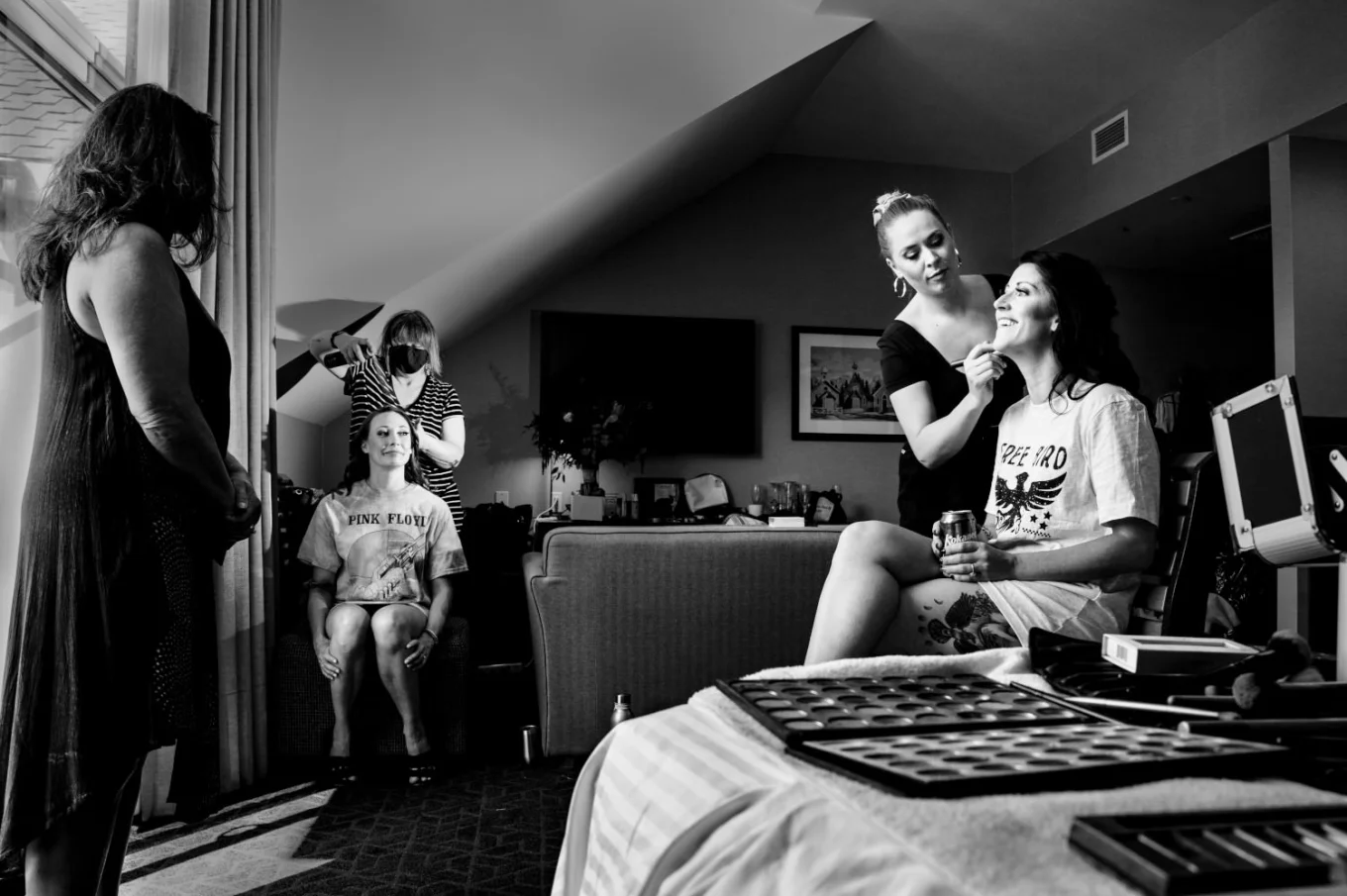 Bride and bridesmaid get their make up done in the hotel room. in Banff.