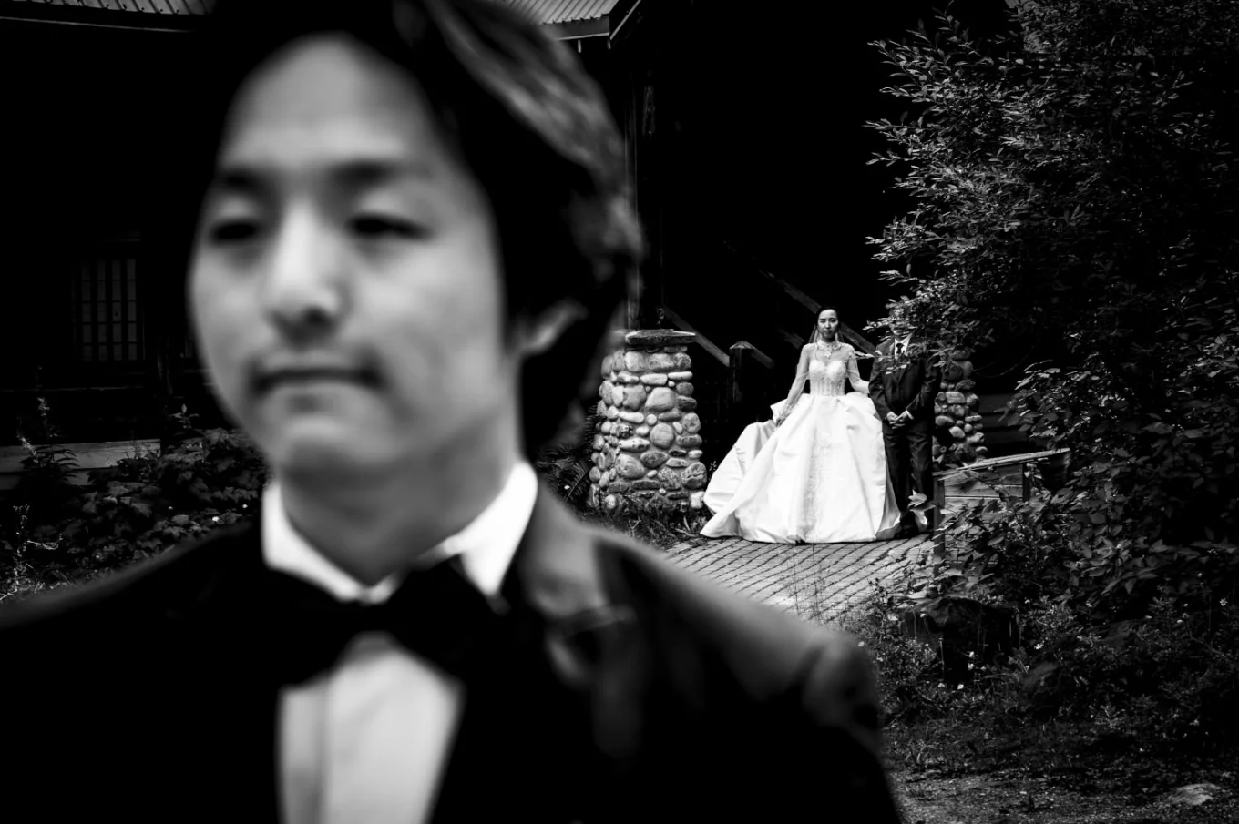 Groom waits for the bride while she walks behind him.