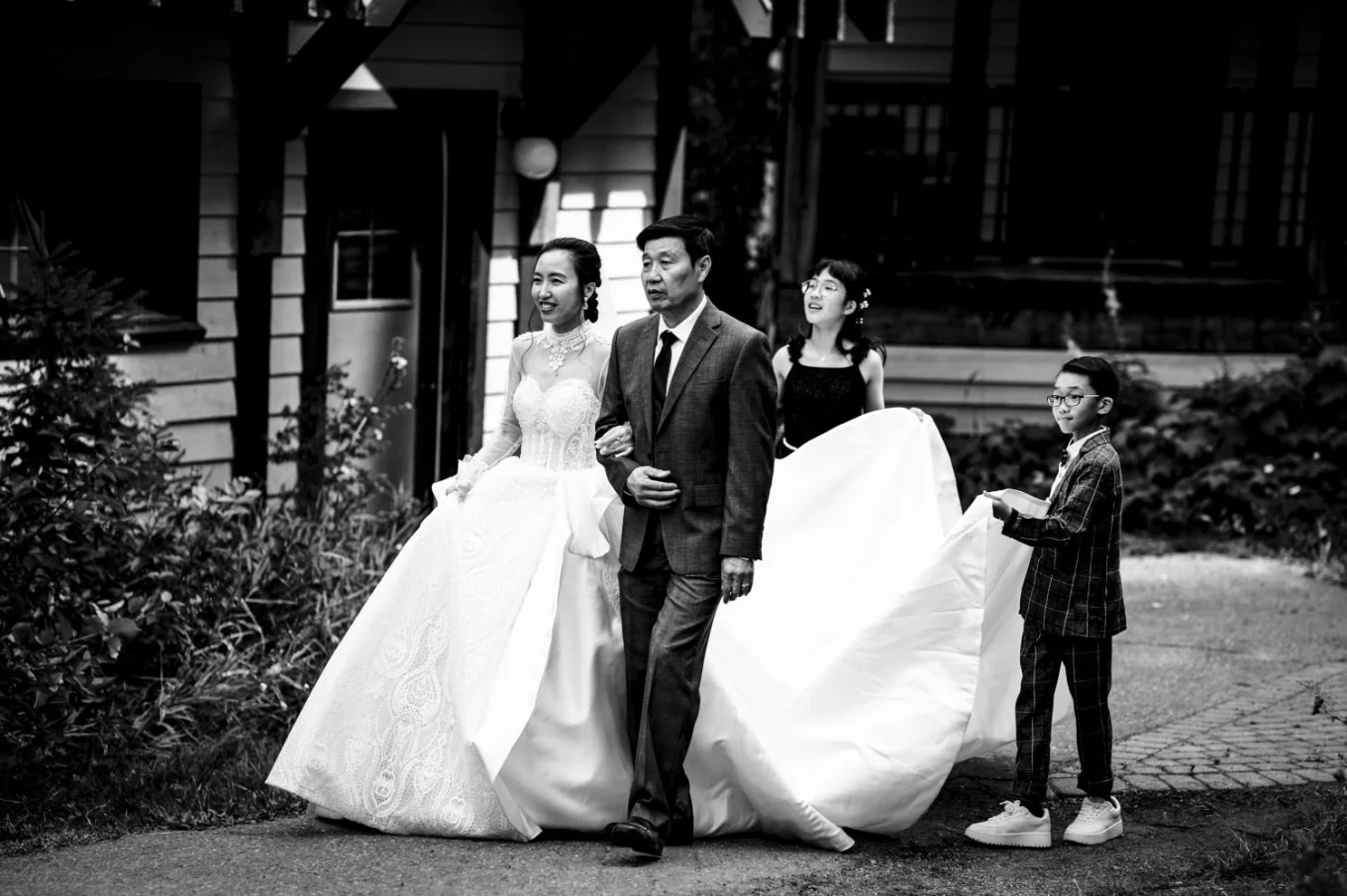 bride and her father heading for the wedding ceremony at Emerald Lake. Kids help with her giant wedding dress.