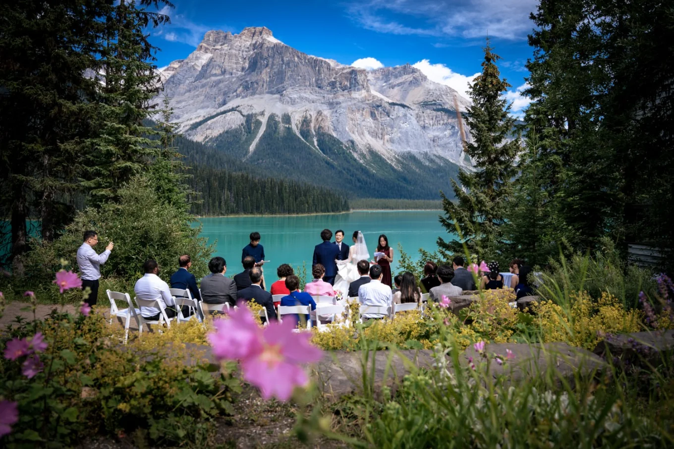 Unique wedding ceremony at Emerald Lake. Guests and newlyweds surrounds by Canadian Rocky Mountains,