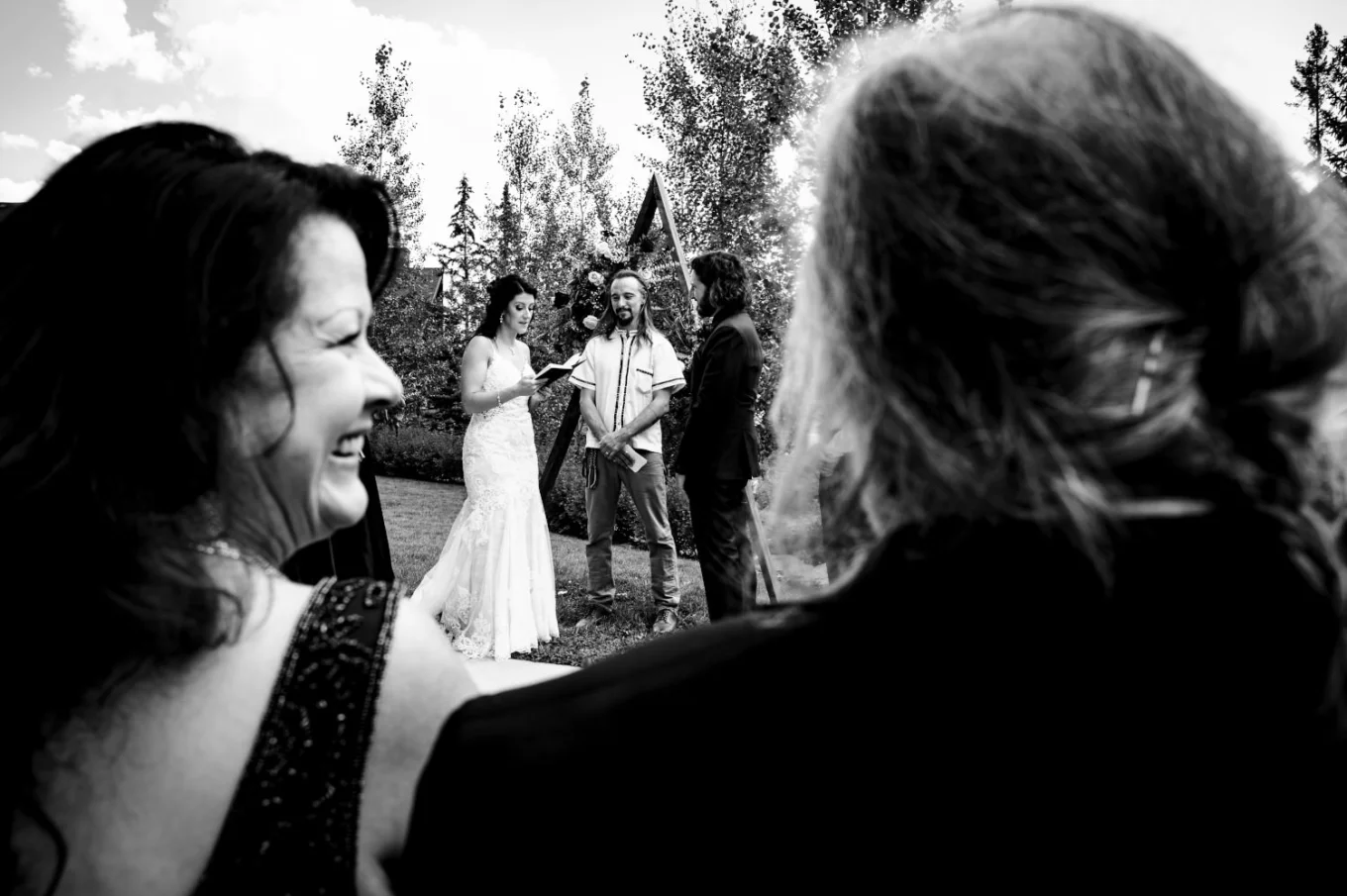 Amazing Candid Photograph in black and white. Shoot through the parents backs while their daughter is getting married in Banff.