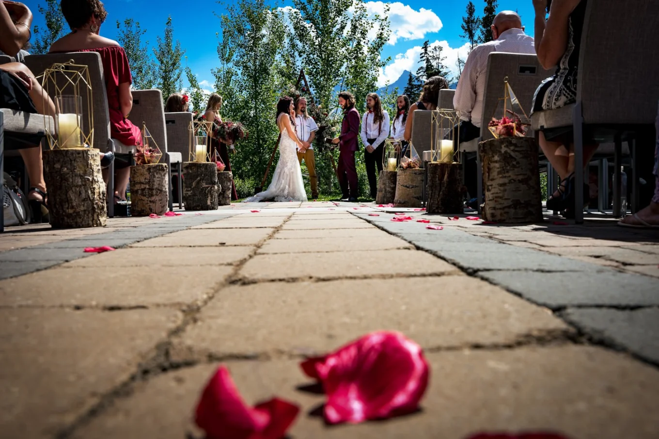 Wedding ceremony in Banff with red rose petals on the ground.