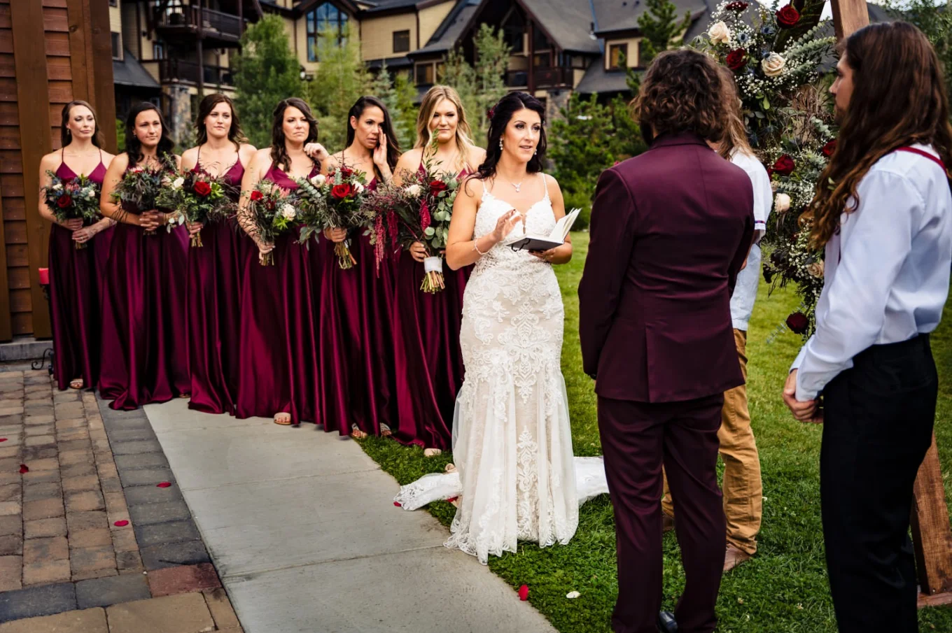 Bride gives a speech on the Wedding Ceremony in Banff. Bridesmaids in red dresses stand next to the bride.
