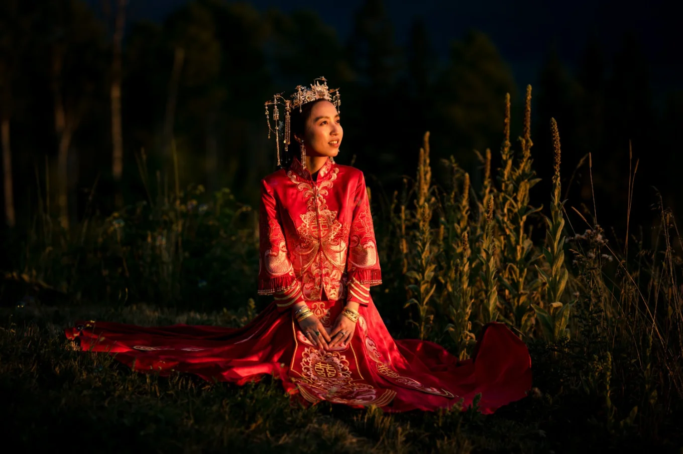 Amazing portrait of the bride sitting in the sun . She wears red, traditional Asian wedding dress.