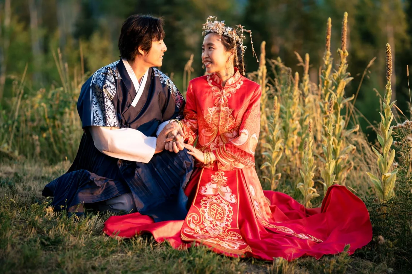 Bride and groom st at the grass. They wear beautiful Asian traditional outfit.