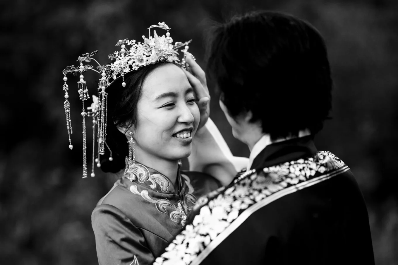 Broom fix bride's hair. Romantic photograph in black and white.