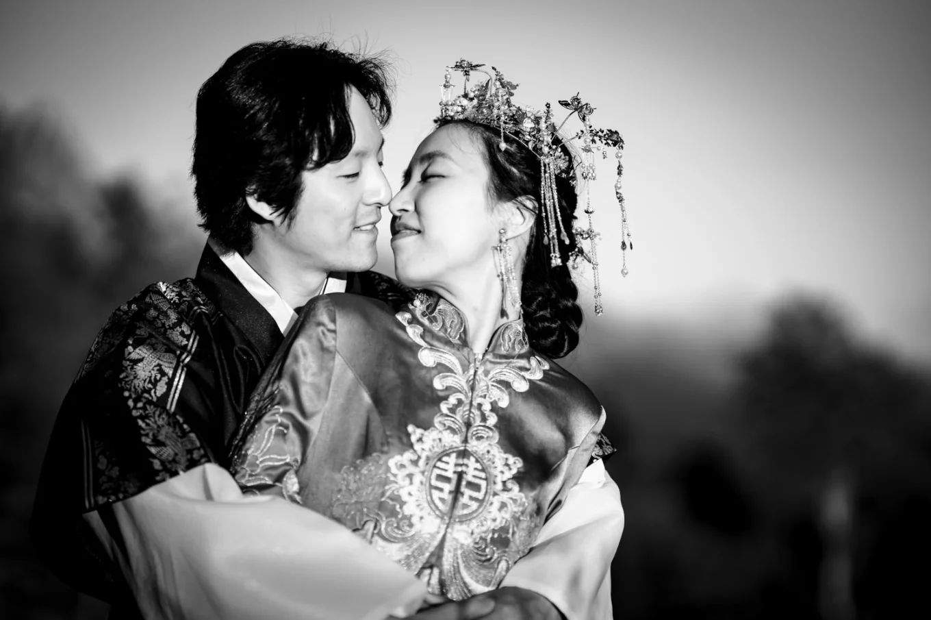 Newlyweds share a kiss. The groom standing behind his wife.