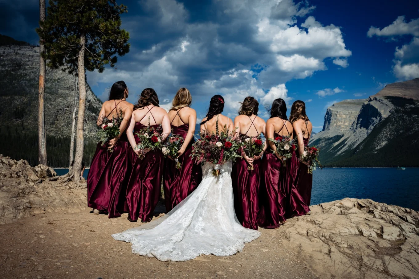 bride and bridesmaids turned back to camera and show their flowers.